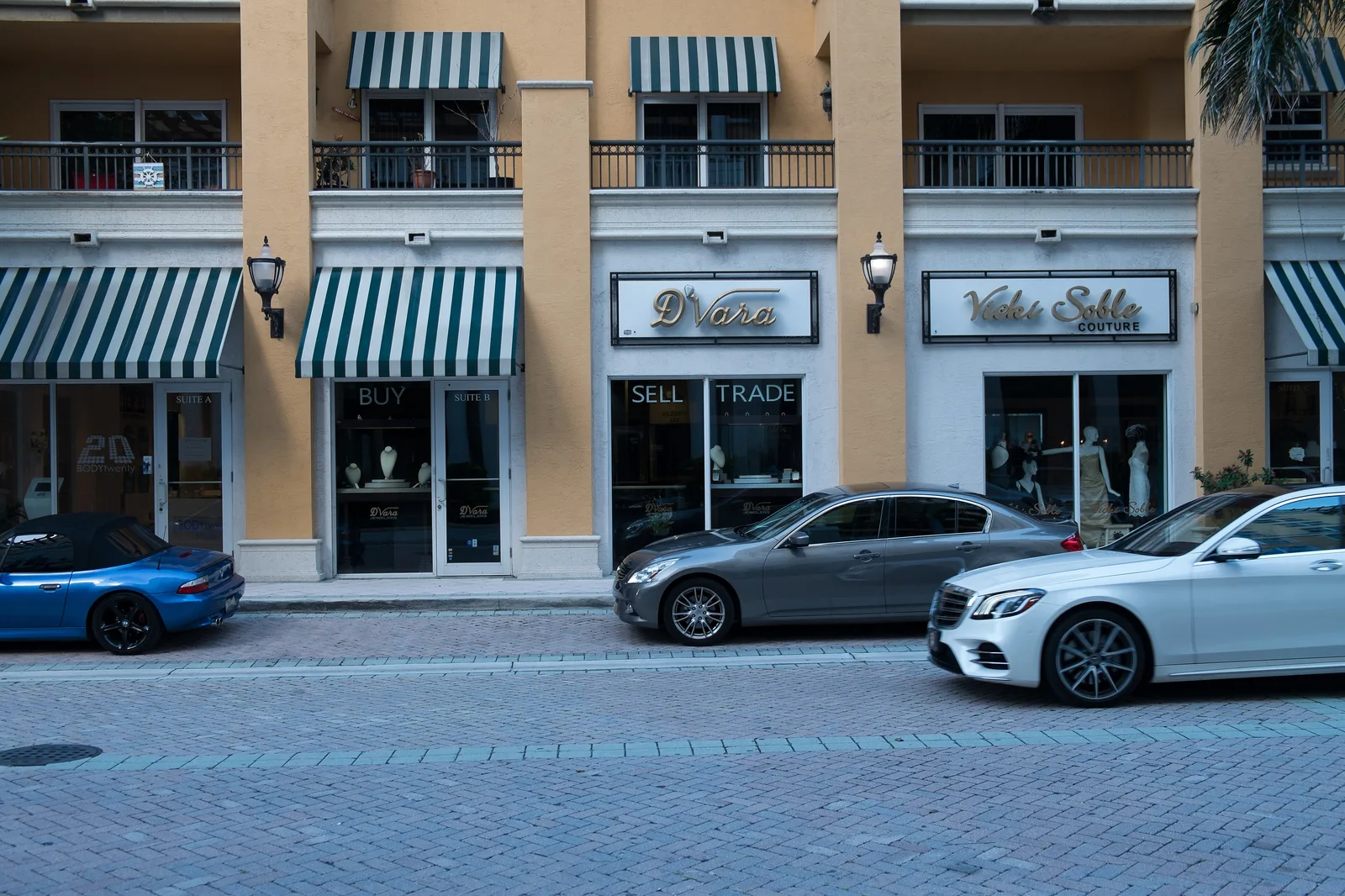 Storefronts with striped awnings along a downtown Boca Raton street.