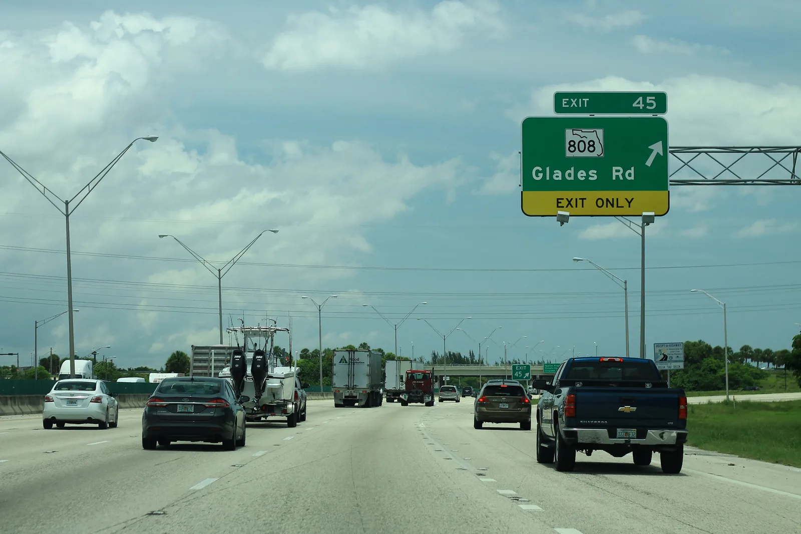 Northbound I-95 at the exit 45 sign for Glades Road, on the west side of Country Club Village in Boca Raton