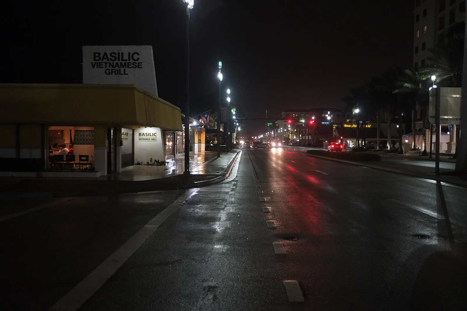 Streetlights along a rain-slicked street in Boca Raton at night.