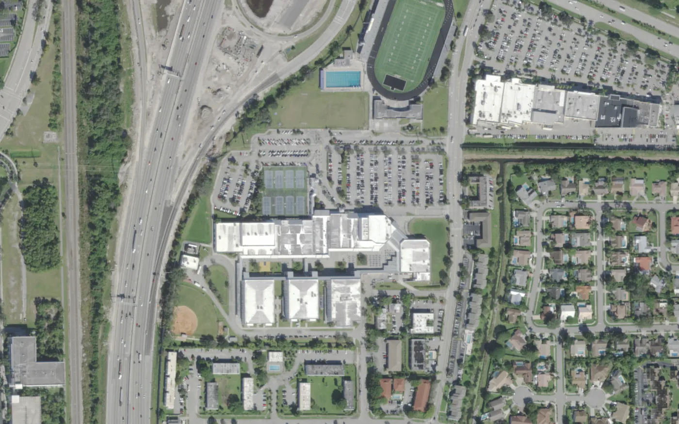 Boca Raton Community High's campus, stadium and pool beside I-95 and Glades Road, seen from the air